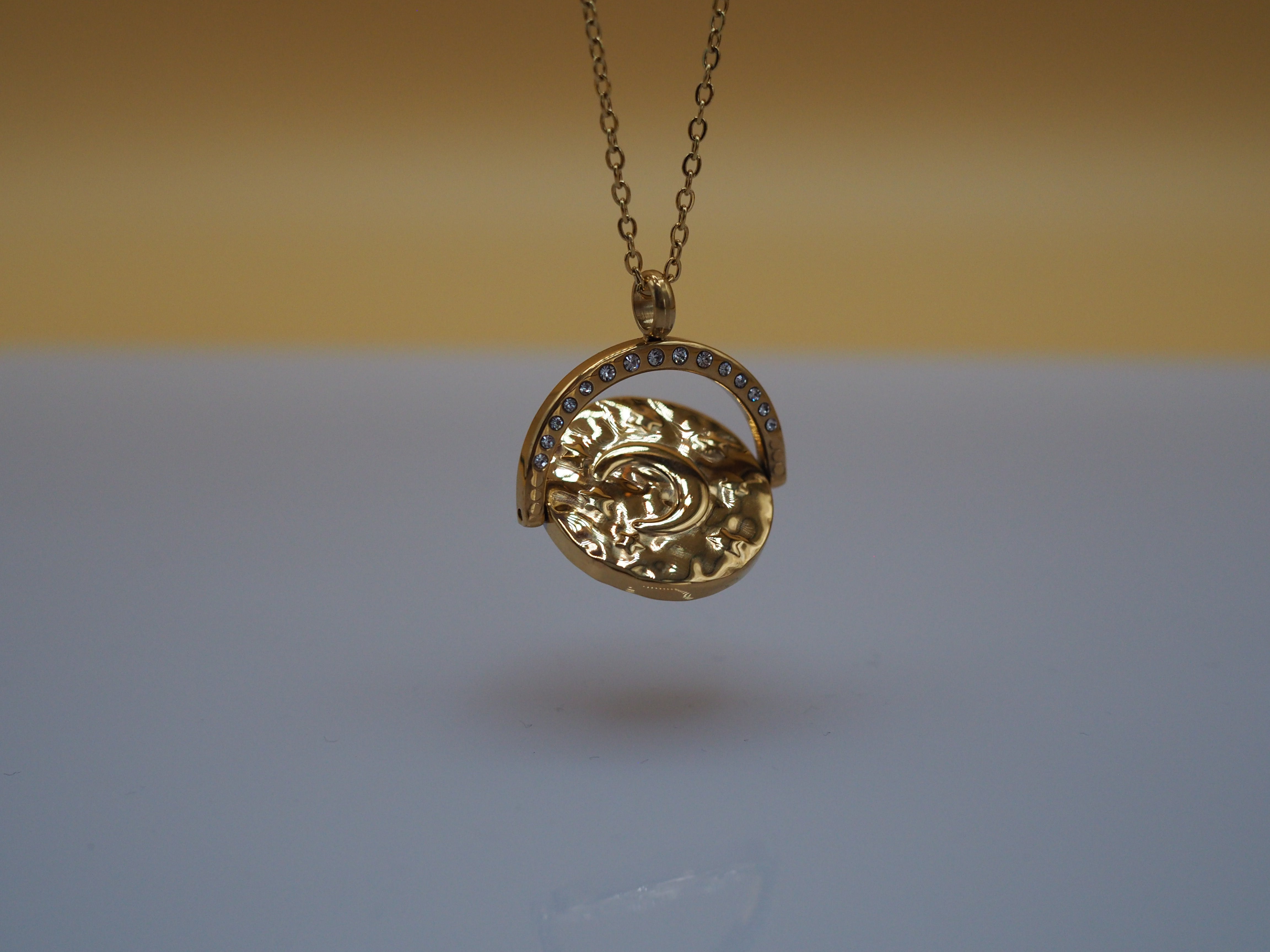 Draaibare gouden hanger met zon en maan symbool – ELARA