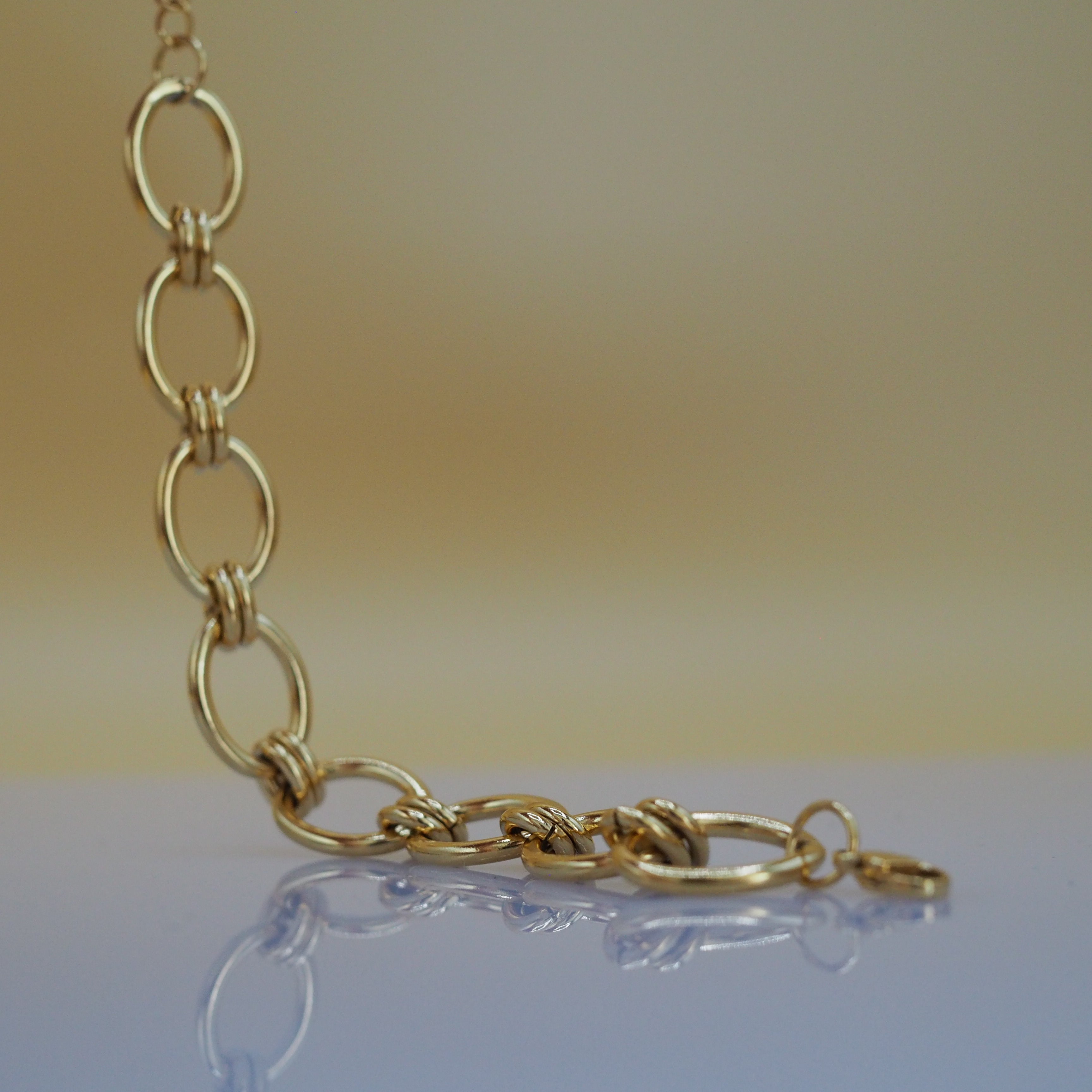 Detail van chunky open schakels van gouden armband